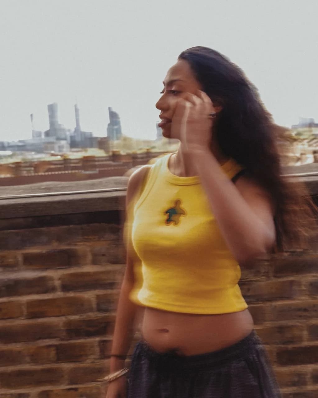 Model wearing the yellow Art Beyond The Shell vest on a rooftop